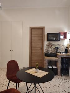 ein Wohnzimmer mit einem Tisch, einem Stuhl und einer Theke in der Unterkunft L'OLIVA CONTESA - alloggio turistico - la ROSSA in Gaeta