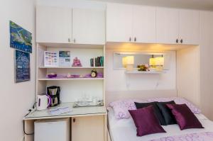 Habitación pequeña con cama y escritorio. en Apartments & Room Frane, en Dubrovnik