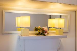 um espelho numa parede com duas lâmpadas numa prateleira em Apartments & Room Frane em Dubrovnik