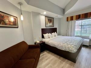 a hotel room with a bed and a couch at HomeTowne Studios & Suites Washington in Washington