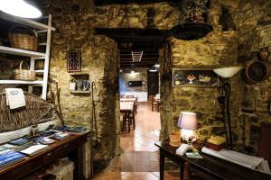 Antico Convento - Ospitalità Diffusa في Rocca Cilento: غرفة بجدران حجرية وطاولة مع مصباح