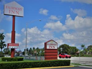 una señal para una posada de campo en un estacionamiento en Fairway Inn Florida City Homestead Everglades en Florida City