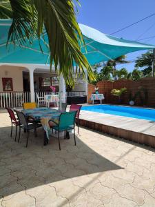d'une terrasse avec une table et des chaises à côté de la piscine. dans l'établissement An ti kaz la, à Sainte-Anne 6 autres photos