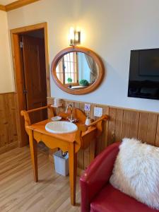 a bathroom with a sink and a mirror and a couch at Auberge au Poste de Traite in Sainte-Famille