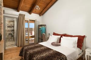 una camera da letto con un letto con lenzuola bianche e cuscini rossi di Mansion D a Galatás