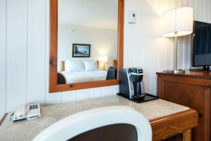 a hotel room with a sink and a mirror at Riotel Perce in Perce