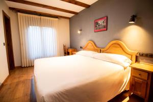 - une chambre avec un grand lit blanc et une fenêtre dans l'établissement Alda Casco Antiguo, à León