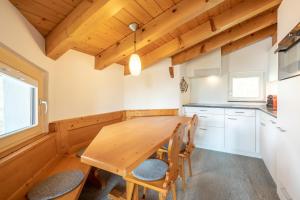 a kitchen with a wooden table and chairs at Casa Darschalè 11 in Laax