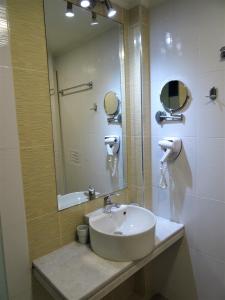 a bathroom with a sink and a mirror at Horizon Beach Hotel in Plakias