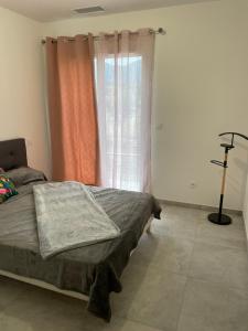 un dormitorio con una cama y una ventana en Villa Jean Baptiste, en Patrimonio