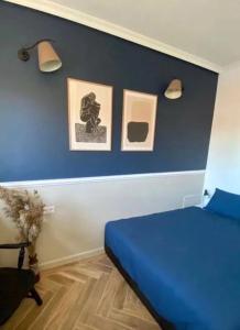 1 dormitorio con 1 cama azul y 2 cuadros en la pared en Apartament Zamkowy 2, en Kwidzyn