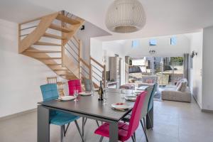 a dining room with a table and colorful chairs at Grande maison pour 8 a St Armel in Saint-Armel