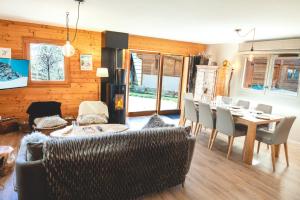 a living room with a table and chairs and a fireplace at Le Chalet des Tartalys - 750 m des pistes de Serre Chevalier Chantemerle in Saint-Chaffrey