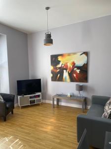 a living room with a couch and a flat screen tv at Chapel View in Ballycastle