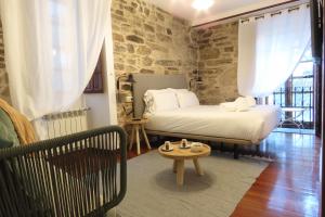 a bedroom with a bed and a table in a room at Sete Artes by Como en Casa in Santiago de Compostela