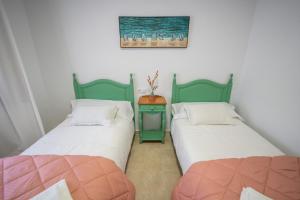 two beds sitting next to each other in a room at LASPALOMAS18 in Sanlúcar de Barrameda