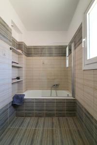 a bath tub in a bathroom with wooden floors at Monolithos Villas in Kipri +37 photos