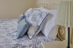 a bed with blue and white pillows on it at Monolithos Villas in Kipri