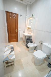 a bathroom with two toilets and a sink and a mirror at LASPALOMAS18 in Sanlúcar de Barrameda +49 photos