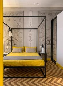 ein Schlafzimmer mit einem Himmelbett mit gelber Bettwäsche in der Unterkunft The347, Diletta in Palermo