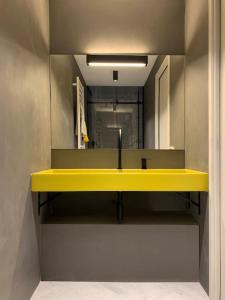 ein Badezimmer mit einem gelben Waschbecken und einem Spiegel in der Unterkunft The347, Diletta in Palermo