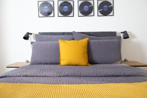 - un lit avec une couette bleue et un oreiller jaune dans l'établissement Armotti Pappelweg Bern, à Berne