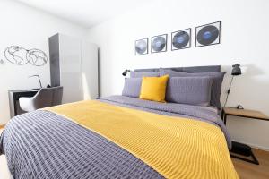 - une chambre avec un lit doté d'une couverture jaune et bleue dans l'établissement Armotti Pappelweg Bern, à Berne