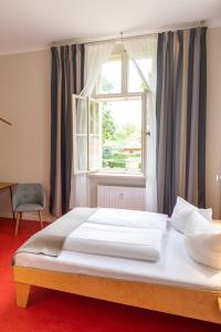 a large bed in a room with a window at Kavaliershaus Krumke - Gästehaus im Schlosspark in Krumke