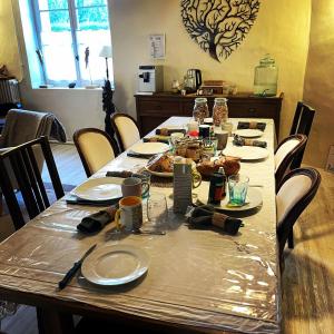 długi stół z talerzami i jedzeniem w obiekcie Osélience w mieście Hermeray