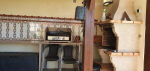 a kitchen with a counter with stools and a microwave at House with pool CASA DA FAIA - AVEIRO (Estarreja) in Avanca