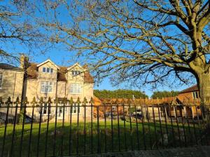 a fence in front of a large house at Stylish 2 Bed Apart In The Heart of North Norfolk in North Walsham