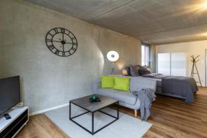 a bedroom with a bed and a clock on the wall at Gohlke L.O.F.T. Apartments in Schorndorf