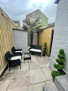 a patio with chairs and tables and a fence at Osborne luxury hot tub and jacuzzi suites in Blackpool