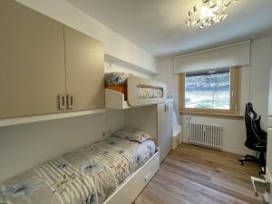 a small bedroom with a bed and a window at 021 Attico Quadrilocale, Pinzolo in Pinzolo