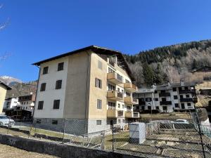an apartment building with a fence in front of it at 021 Attico Quadrilocale, Pinzolo in Pinzolo