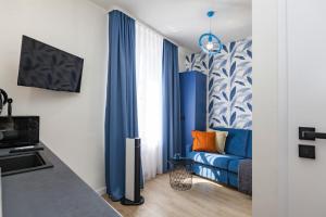 sala de estar con cortinas azules y sofá azul en Cracow city heart - 19th-century tenement house of Stanislaw Wyspianski, en Cracovia