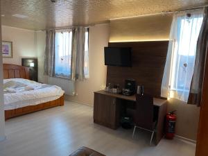 a bedroom with a bed and a desk with a television at Complex Koko Hills in Sapareva Banya