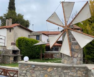 un grand moulin à vent en pierre devant une maison dans l'établissement Villa Makri, à Nea Makri