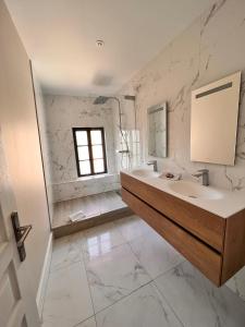 a white bathroom with a sink and a mirror at Dans ma Bulle - Les Balcons de la Cité in Carcassonne