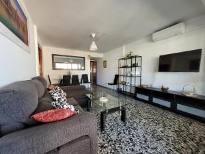 uma sala de estar com um sofá e uma televisão de ecrã plano em Tor Serena-Fincas Benidorm em Benidorm