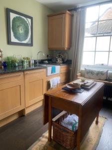 a kitchen with a table in the middle of it at Comfortable 2 Bedroom Apartment in Lavish Holland Park with Balcony in London