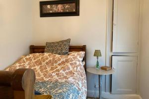 a bedroom with a bed and a side table at Comfortable 2 Bedroom Apartment in Lavish Holland Park with Balcony in London