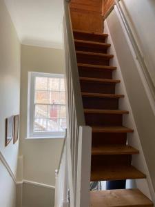a staircase in a house with a window at Comfortable 2 Bedroom Apartment in Lavish Holland Park with Balcony in London