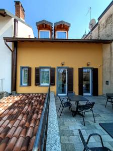 un patio con tavoli e sedie su una casa di Il B&B di Piazza Motta ad Albese Con Cassano