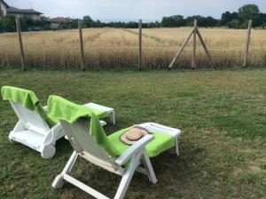 due sedie da giardino con un cappello in un campo di Porte di Venezia, Tessera Aeroporto a Favaro Veneto
