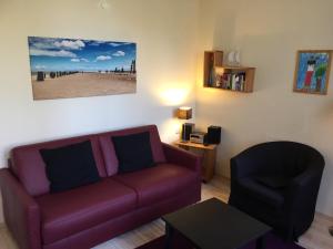 ein Wohnzimmer mit einer Couch und einem Sessel in der Unterkunft Ferienwohnung Sandrose in Wangerooge
