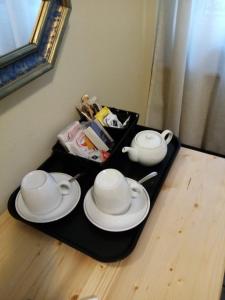 a tray with two teapots and two cups on a table at L'Angelo Blu in La Spezia
