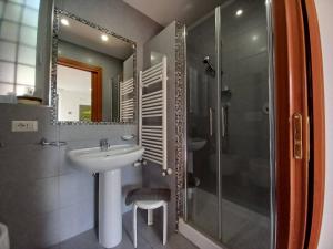 La salle de bains est pourvue d'un lavabo et d'une douche. dans l'établissement L'Oasi al Pigneto - Guest house, à Rome