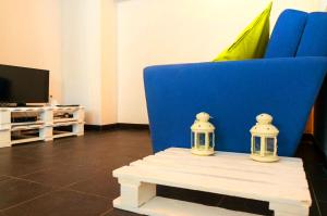 里斯本的住宿－卡爾尼德度假屋，客厅的一张带两张蜡烛的蓝色椅子