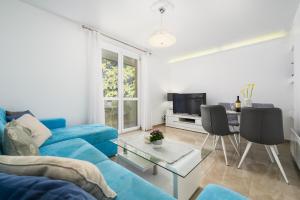 a living room with a blue couch and a table at Premium apartment Peschiera Porec in Poreč